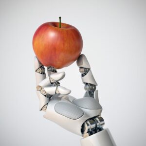 A metallic robot hand holding a red apple.
